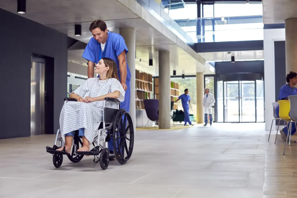 male medical assistant helping lady in wheel chair