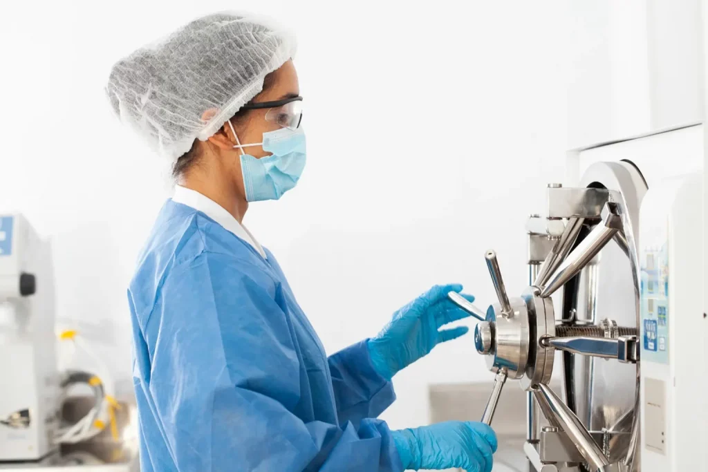 women in lab coat sterilizing lab material
