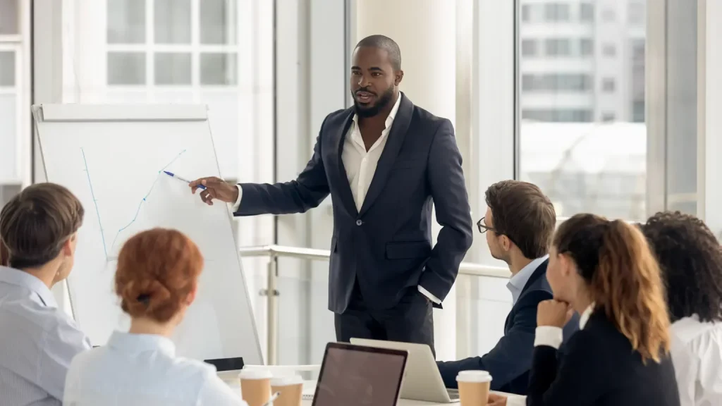 black male presenting data to colleagues in meeting