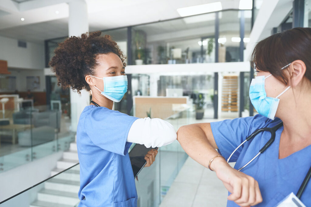 2 health care worker greeting each other