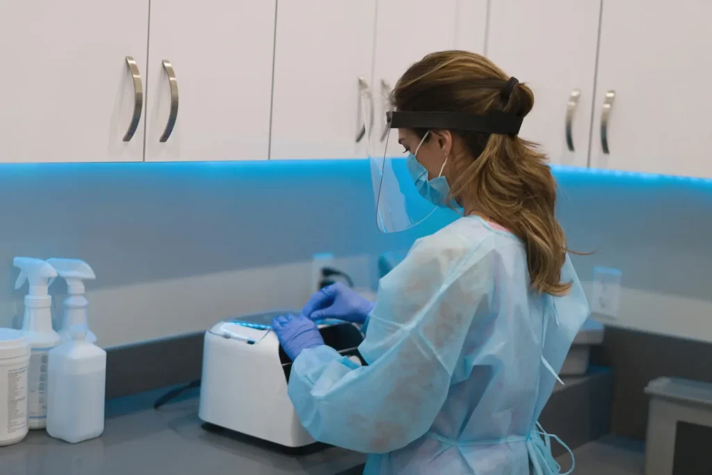 women in lab coat cleaning medical supplies